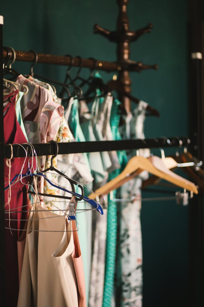 A collection of elegant dresses hanging on a clothes rack in a stylish wardrobe setup.